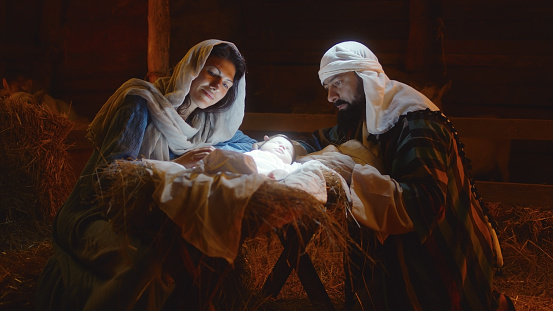 Picture of Mary and Joseph looking at a baby Jesus in a manager.